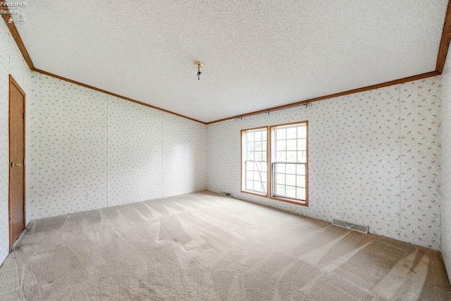 carpeted empty room with a textured ceiling and crown molding