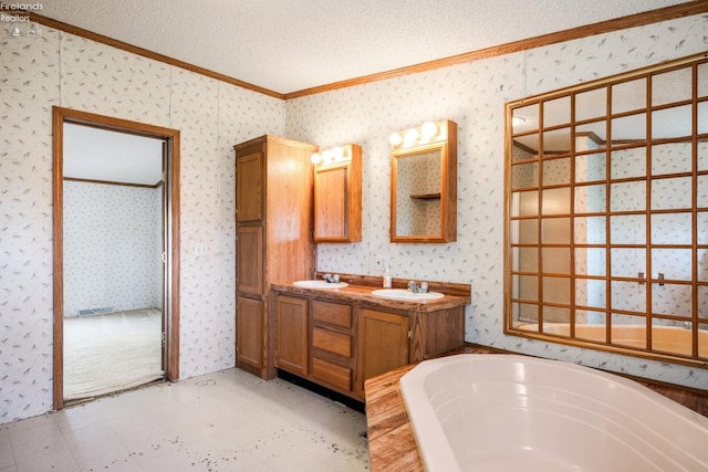 bathroom with a bath, a textured ceiling, crown molding, and vanity