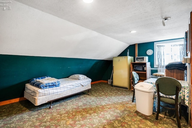 bedroom featuring lofted ceiling, a textured ceiling, and dark colored carpet