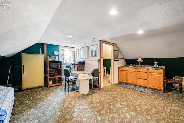 carpeted office space with a textured ceiling and lofted ceiling