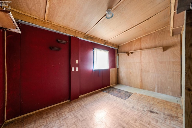 interior space featuring wood walls, light parquet floors, vaulted ceiling, and wooden ceiling