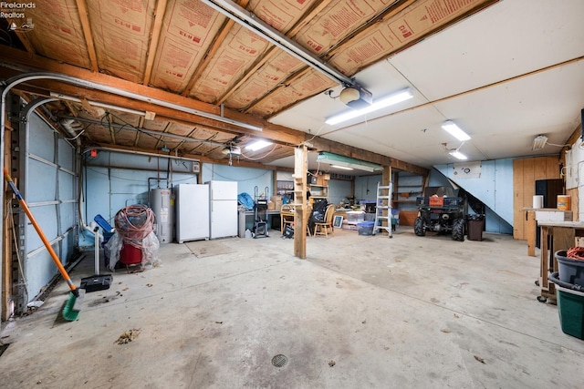 garage featuring electric water heater, white fridge, and a garage door opener