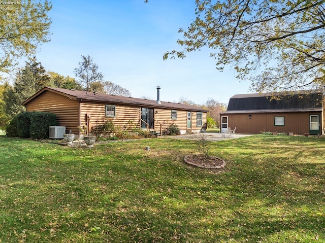 rear view of property featuring central AC unit and a yard