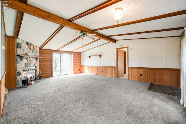 unfurnished living room with ceiling fan, a textured ceiling, carpet flooring, and lofted ceiling with beams