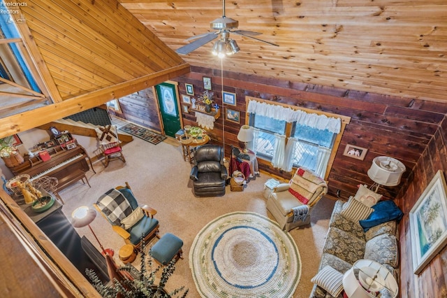 carpeted living room featuring wood ceiling, wood walls, high vaulted ceiling, and ceiling fan