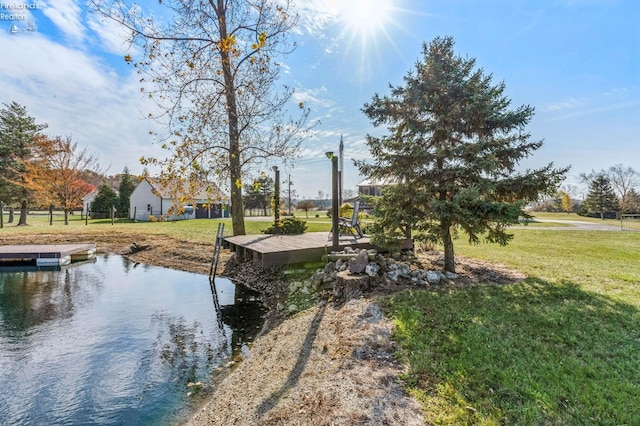 dock area with a yard and a water view