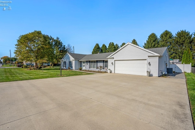 ranch-style home featuring central air condition unit, a front yard, and a garage