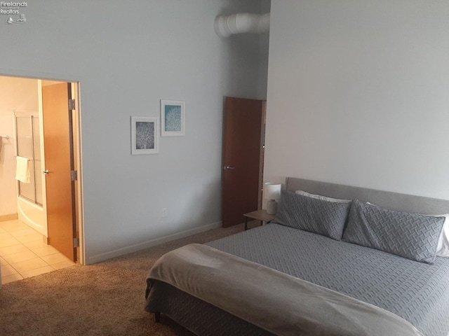 bedroom with ensuite bath and light carpet