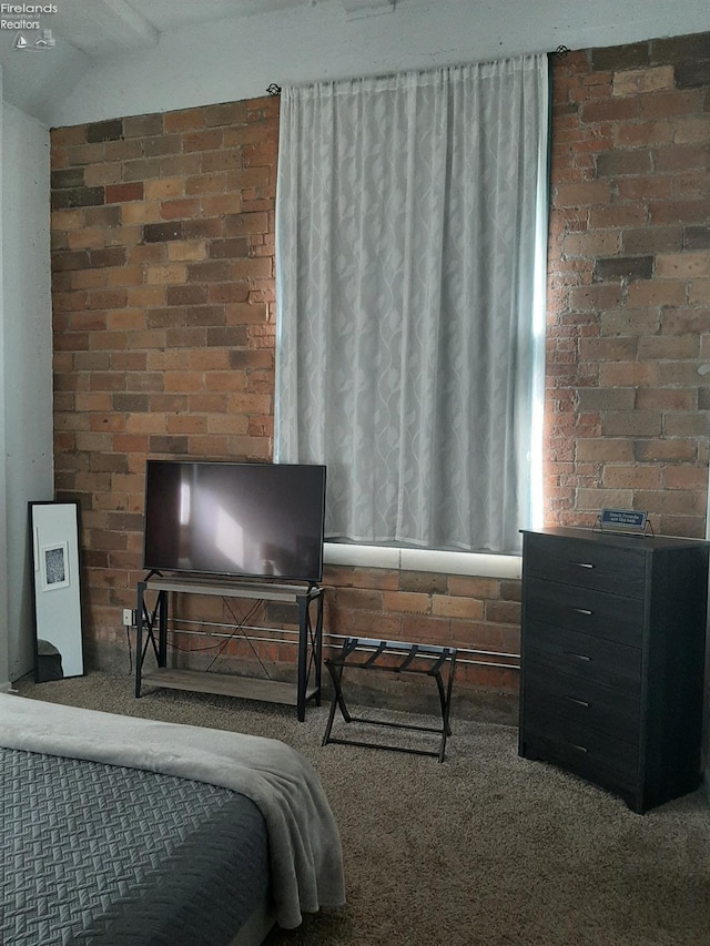 bedroom featuring brick wall and carpet floors