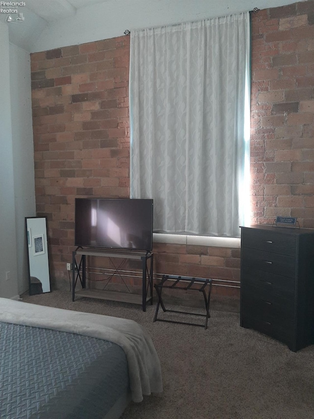 bedroom with brick wall and carpet