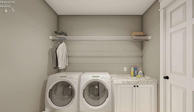 laundry area with washing machine and dryer and cabinets