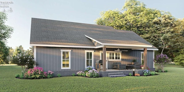 rear view of property featuring a lawn and ceiling fan