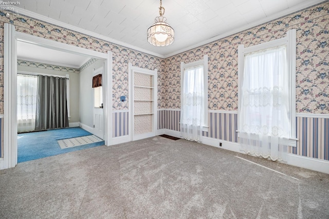 carpeted spare room with crown molding and plenty of natural light