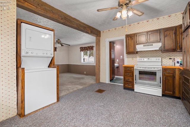 kitchen featuring beam ceiling, electric range, stacked washing maching and dryer, a textured ceiling, and dark carpet