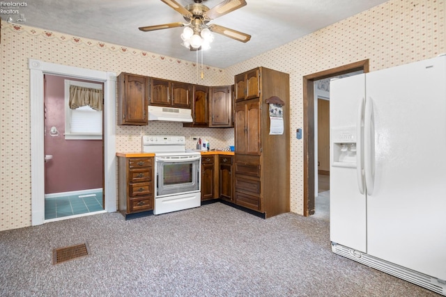 kitchen featuring white appliances, ceiling fan, and carpet