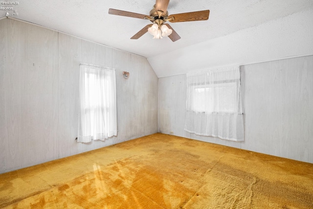 additional living space with ceiling fan, a textured ceiling, carpet flooring, and vaulted ceiling