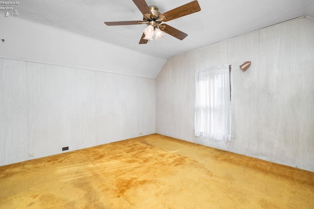 additional living space with lofted ceiling, carpet flooring, a textured ceiling, and ceiling fan