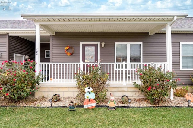 property entrance featuring covered porch and a lawn