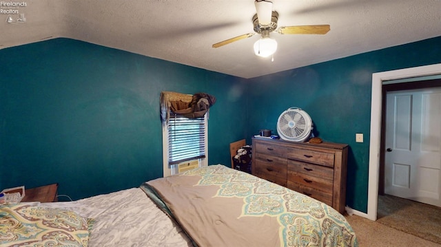 bedroom featuring a textured ceiling, carpet, ceiling fan, and vaulted ceiling