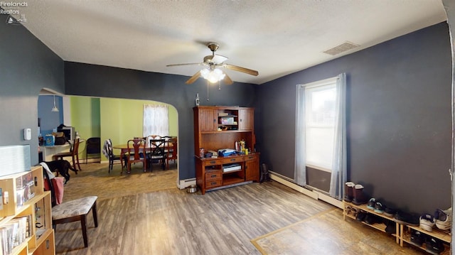 office area featuring a textured ceiling, hardwood / wood-style flooring, ceiling fan, and a baseboard radiator