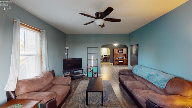 living room with ceiling fan and dark hardwood / wood-style flooring