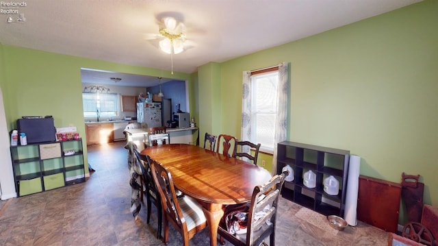 dining space featuring ceiling fan and sink