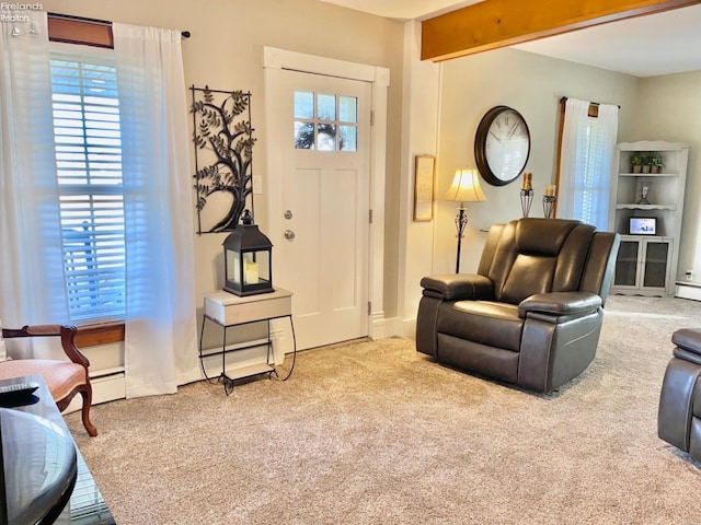 interior space with beam ceiling, carpet, a baseboard heating unit, and plenty of natural light