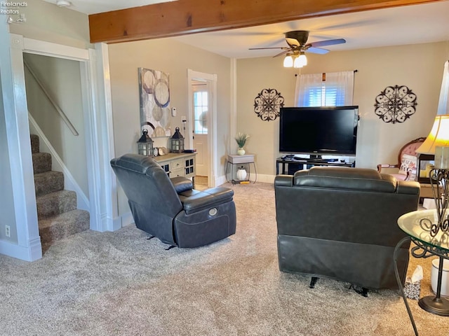 carpeted living room with ceiling fan and beamed ceiling