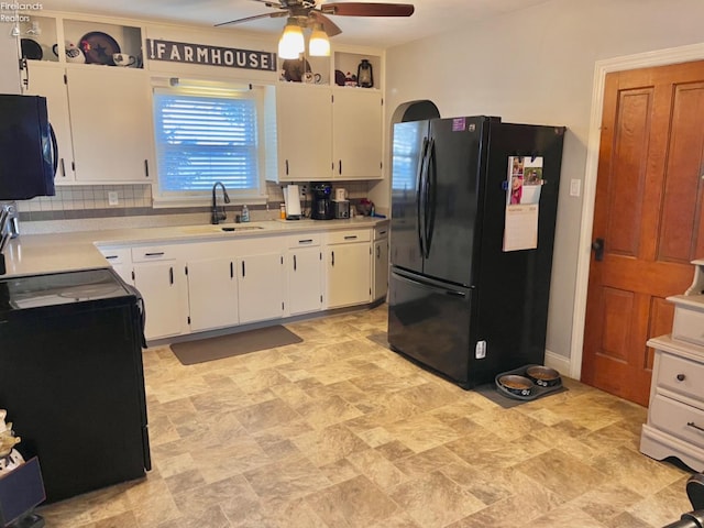 kitchen with white cabinetry, black appliances, sink, and backsplash