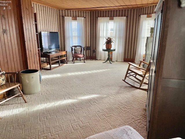 interior space featuring wood ceiling, a healthy amount of sunlight, carpet flooring, and wood walls