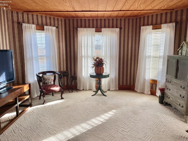 living area featuring wood ceiling, light colored carpet, and a wealth of natural light