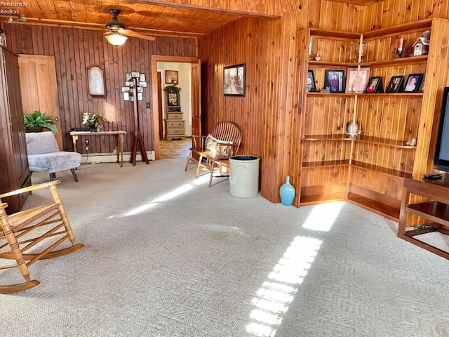 living area featuring wood walls, wood ceiling, carpet floors, and ceiling fan