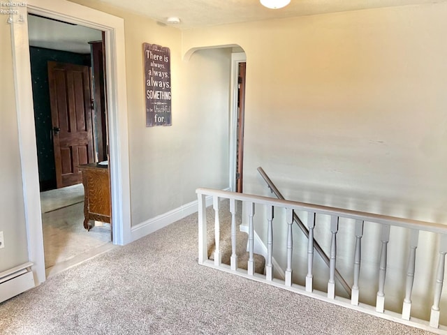 hallway with a baseboard radiator and carpet floors