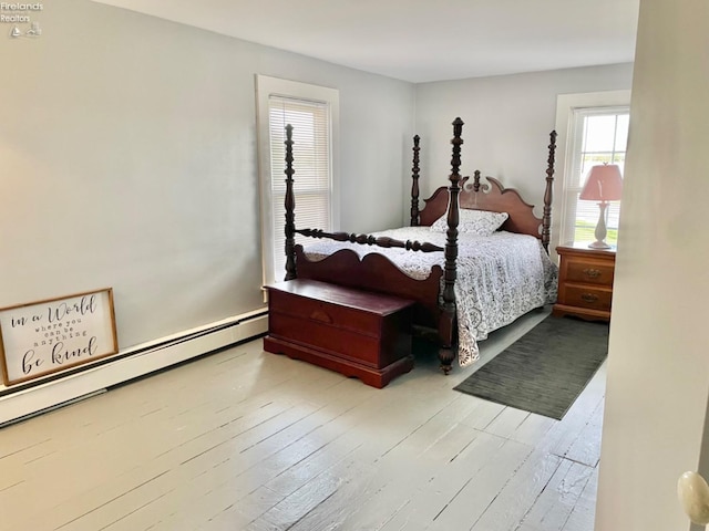 bedroom with light hardwood / wood-style flooring and a baseboard radiator