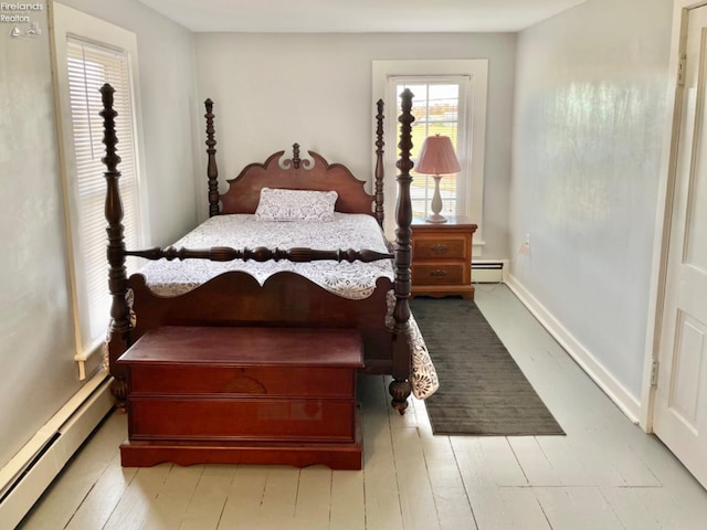 bedroom with light hardwood / wood-style floors and a baseboard radiator