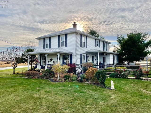 view of front facade with covered porch and a lawn