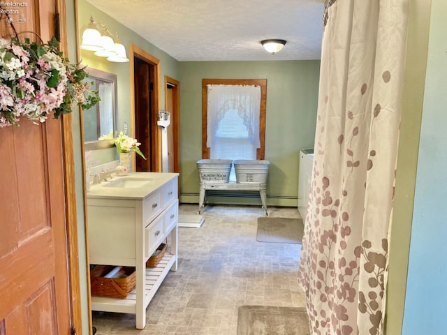 bathroom with vanity, a baseboard heating unit, and a textured ceiling