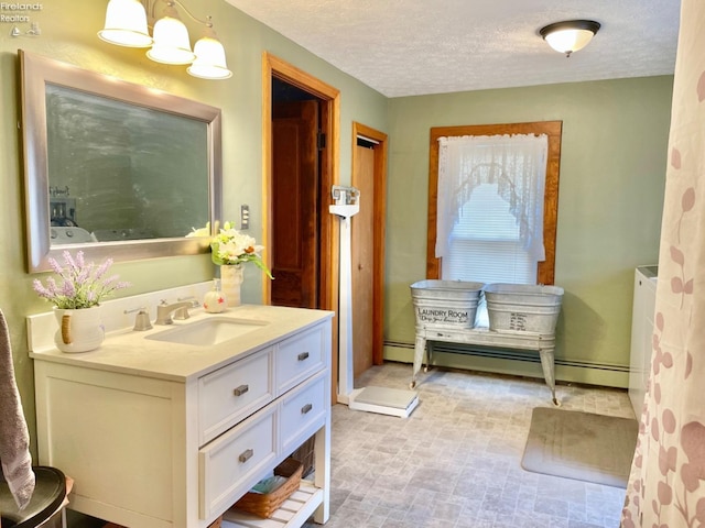 bathroom with baseboard heating, vanity, and a textured ceiling