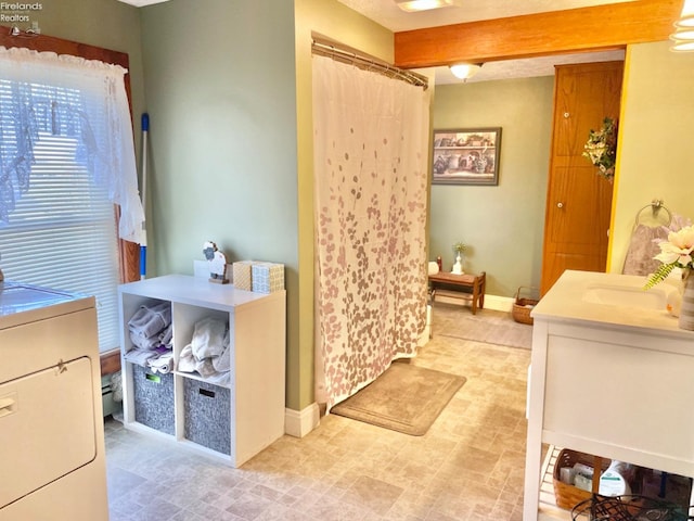 bathroom with vanity, beam ceiling, and toilet