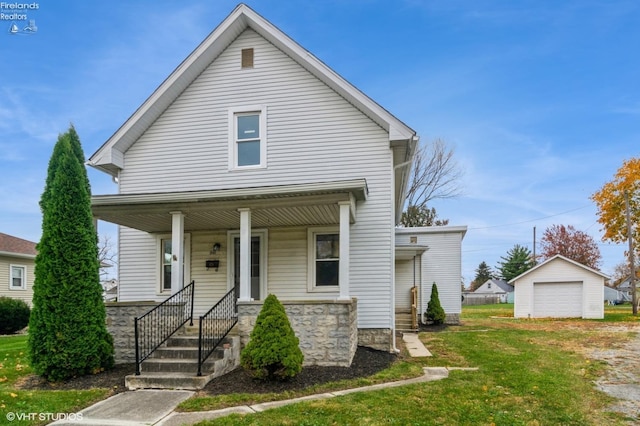 view of front of property with covered porch, a front yard, an outbuilding, and a garage