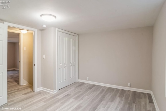 unfurnished bedroom with a closet and light hardwood / wood-style flooring