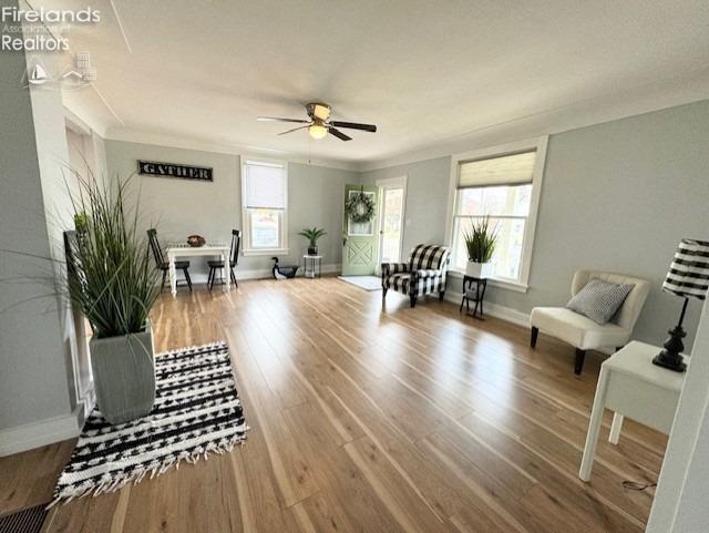 living area with hardwood / wood-style flooring and ceiling fan