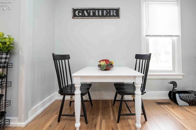 dining space with hardwood / wood-style flooring and a healthy amount of sunlight