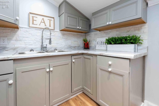 kitchen featuring gray cabinetry, sink, and backsplash