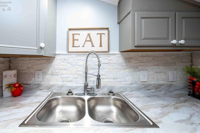 kitchen with gray cabinets, tasteful backsplash, and sink