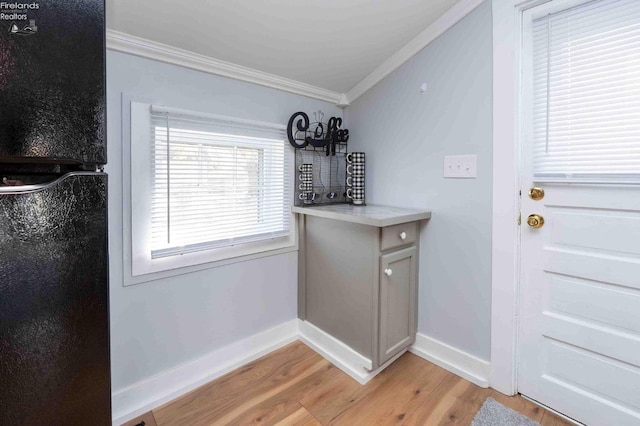 doorway to outside featuring light hardwood / wood-style floors and crown molding