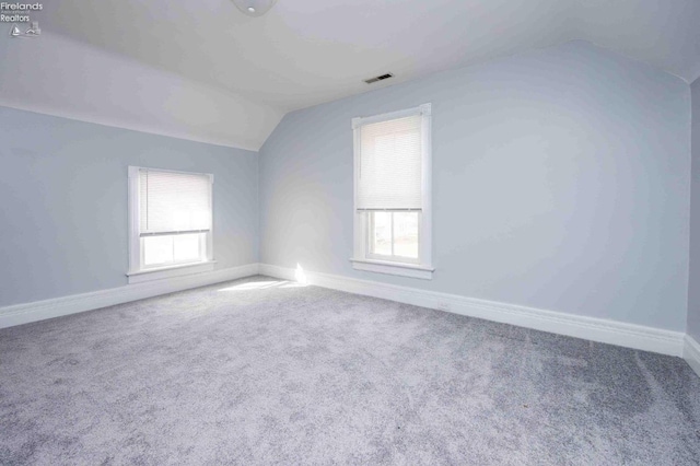 unfurnished room with vaulted ceiling and carpet flooring