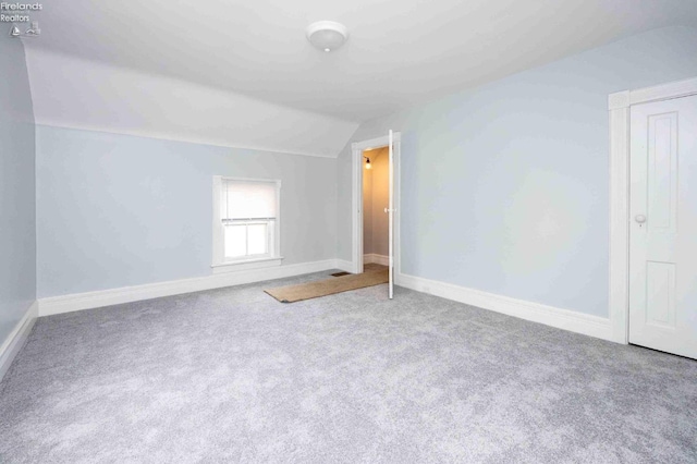 empty room with carpet and vaulted ceiling