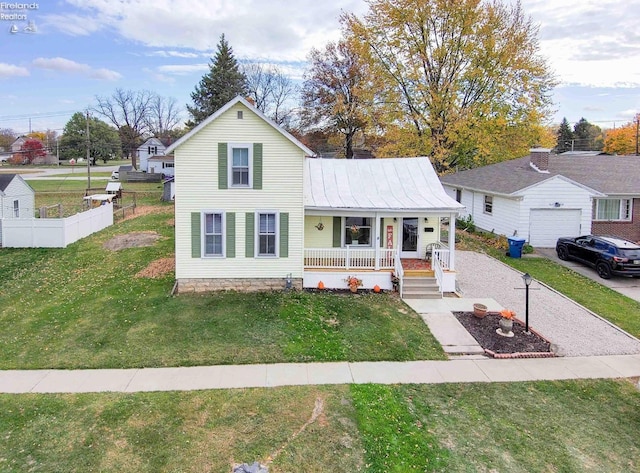 view of front of property with covered porch, a garage, an outdoor structure, and a front lawn