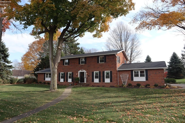 colonial home featuring a front lawn